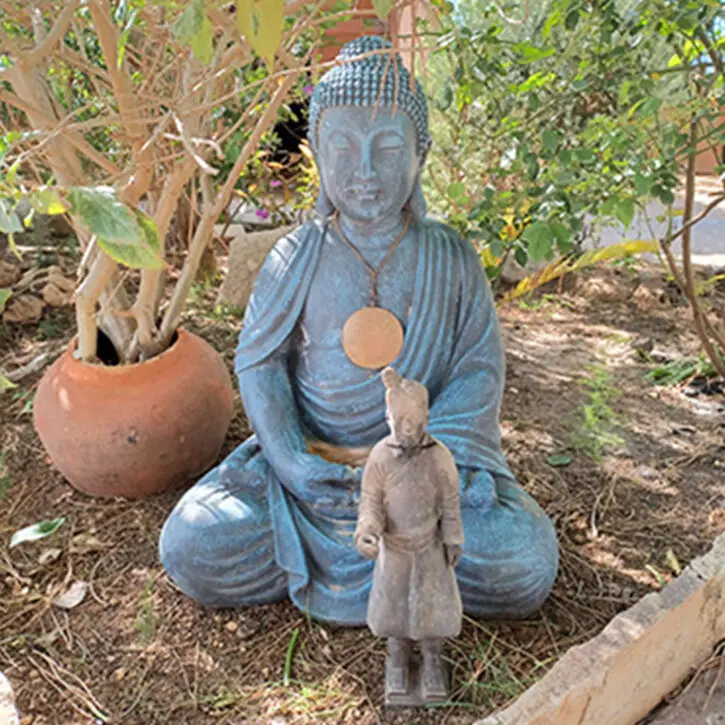 Heilpraktikerin Winsen Luhe – Naturheilpraxis & Homöopathie. Auf dem Bild zu sehen, eine Buddha-Statur aus Stein mit einer Kette um den Hals, davor noch eine weitere Statur